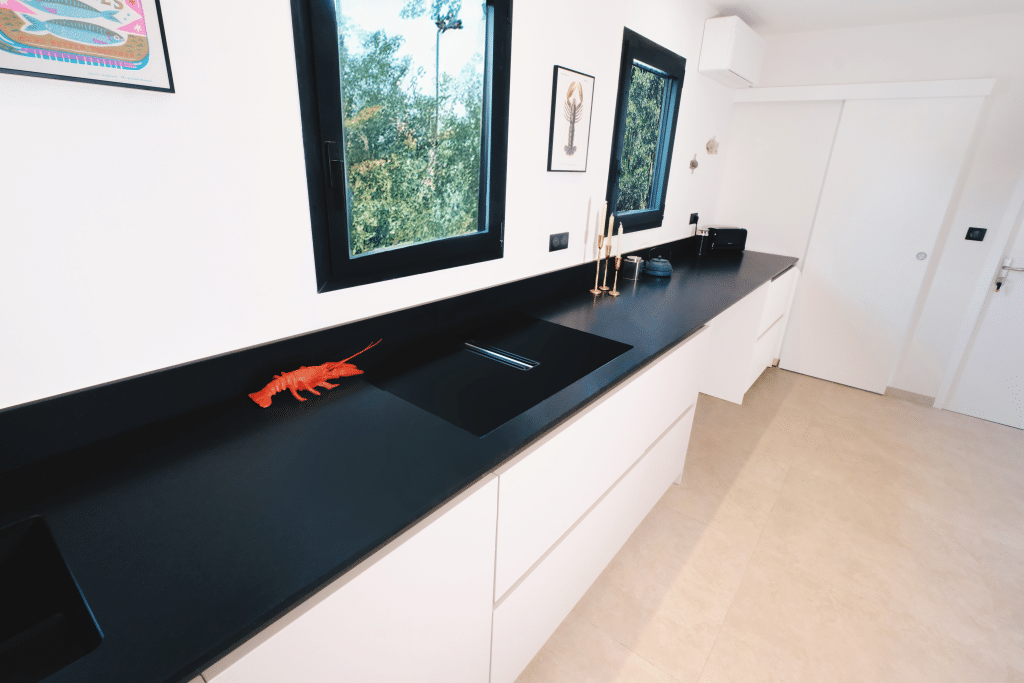 Rénovation d'une cuisine meubles sur-mesure plaque de cuisson avec hotte intégrée à Salles-sur-mer par Design17